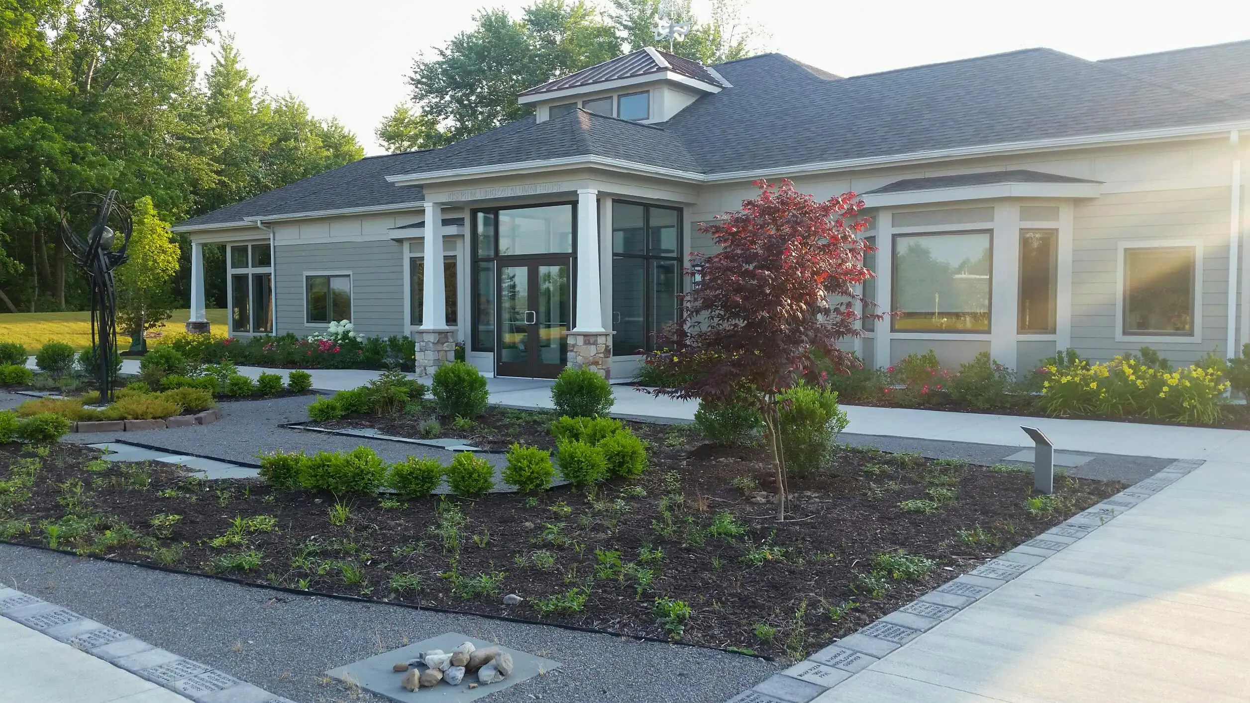 RIT Alumni House entrance landscape design with stone features and sustainable plantings by Costich Engineering landscape architecture Henrietta NY