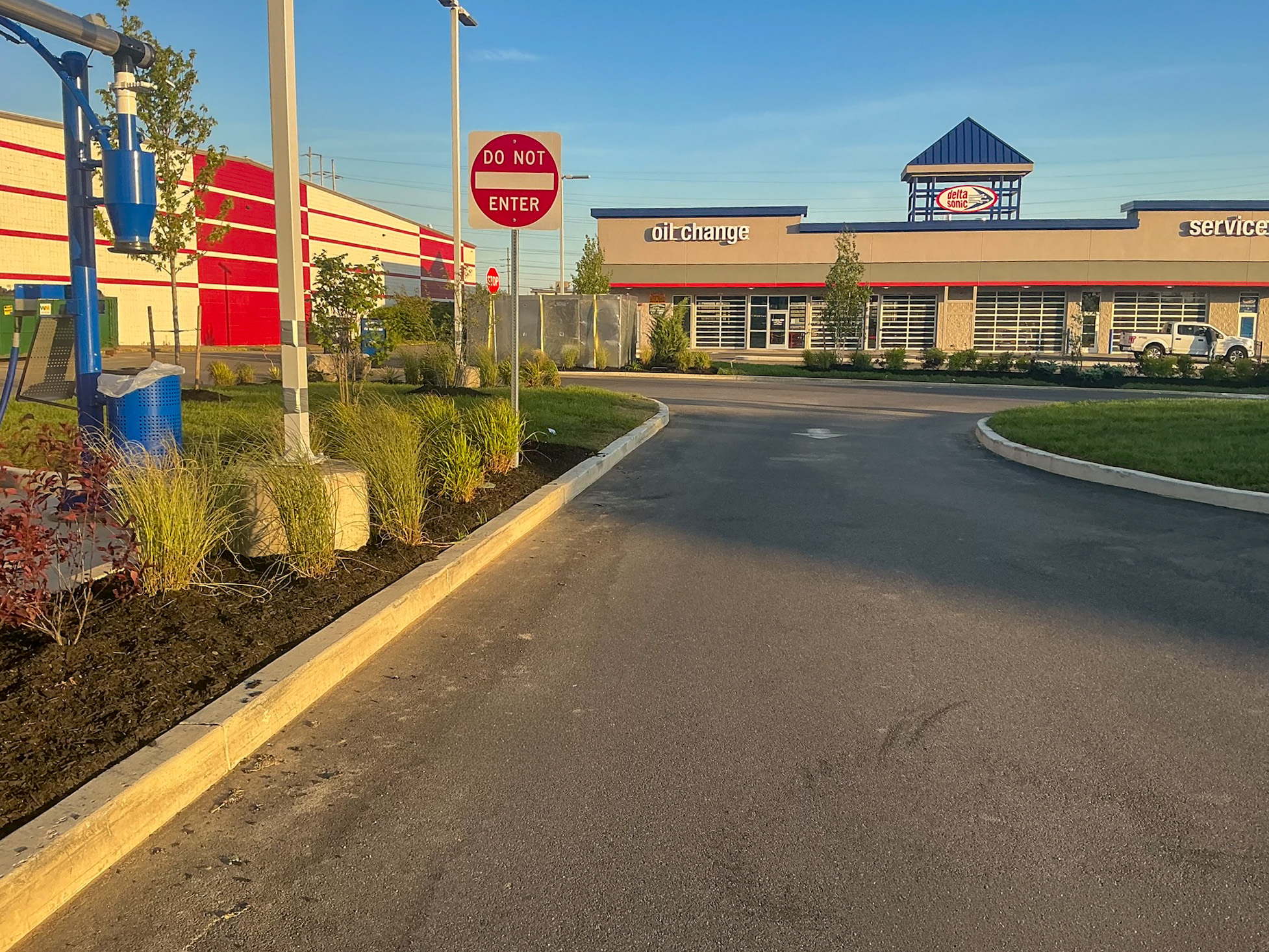 Delta Sonic West Henrietta circulation showing DO NOT ENTER sign, landscape plantings, and clear traffic flow between carwash and service buildings.