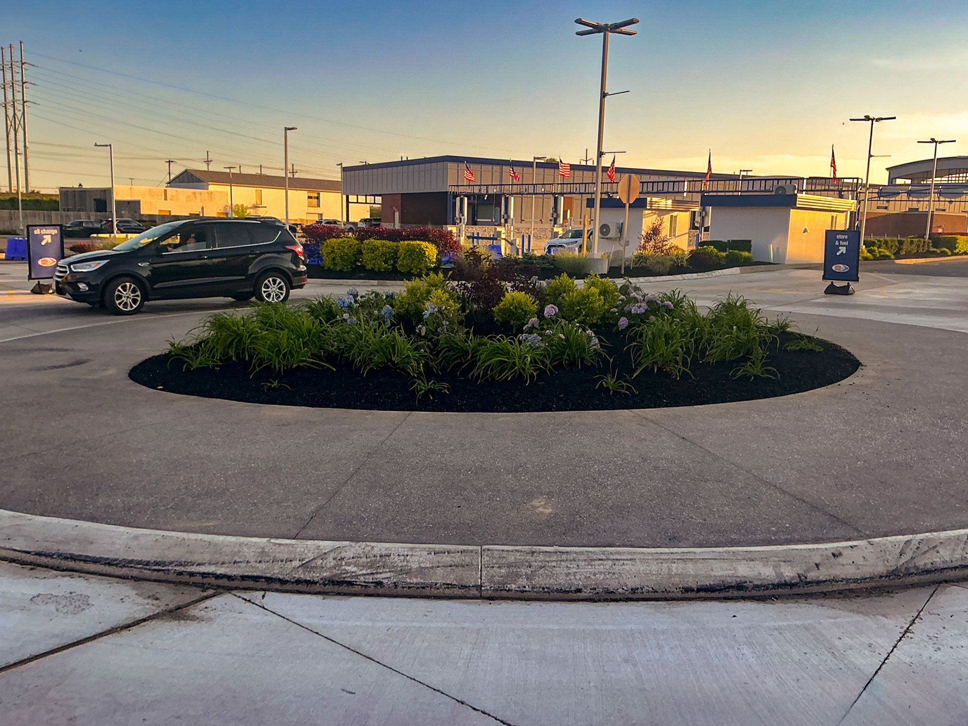 Delta Sonic West Henrietta roundabout featuring central landscape island with ornamental plantings, guiding vehicle circulation and improving traffic flow.