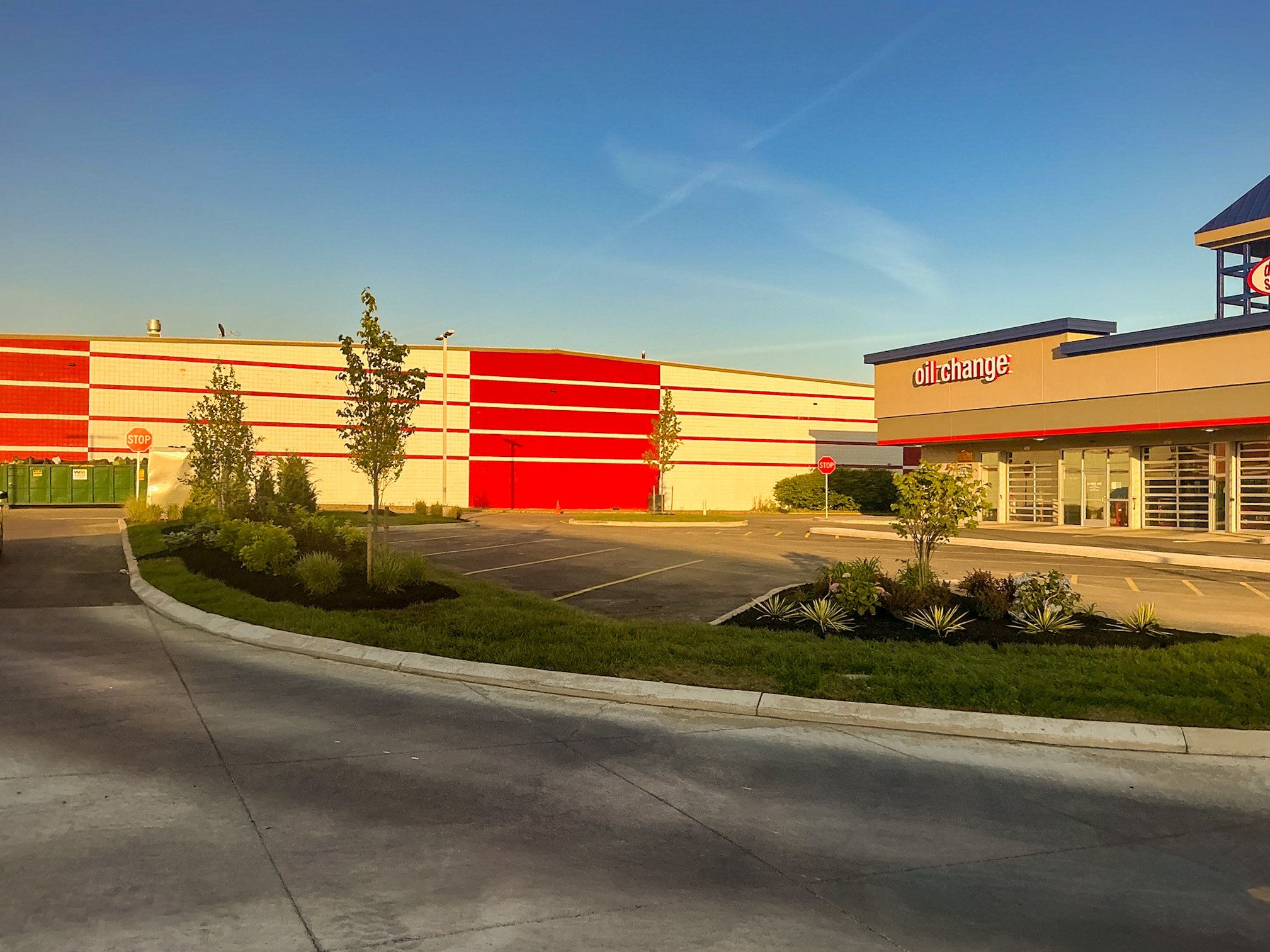 Delta Sonic West Henrietta oil change and service building showing landscape islands, ornamental plantings, concrete edging, and improved parking circulation.