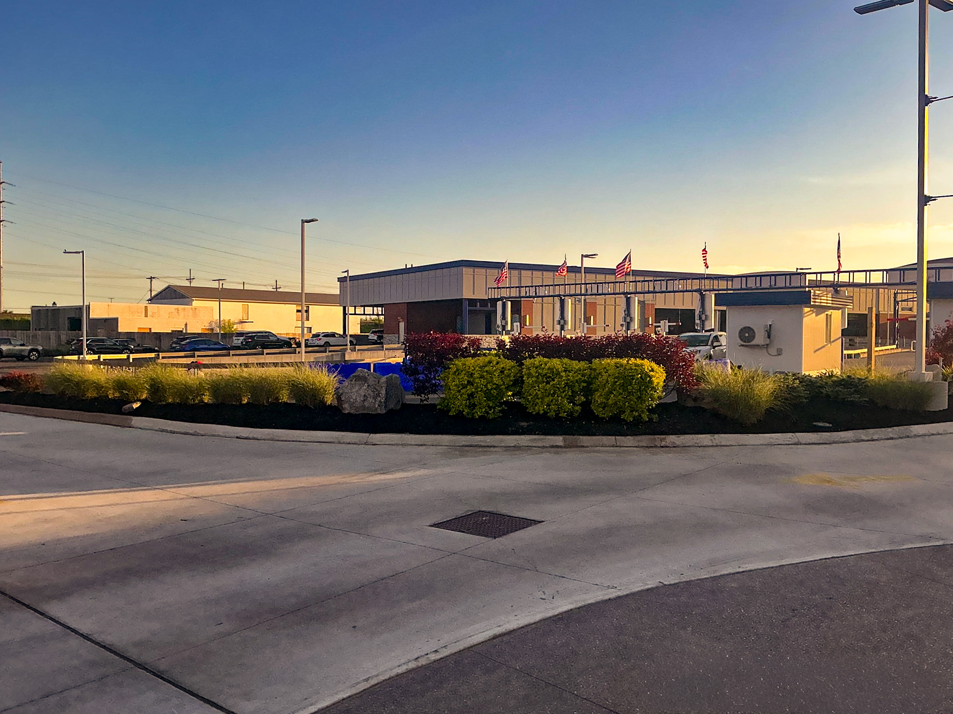 Delta Sonic West Henrietta main carwash building framed by landscape design, ornamental plantings, boulders, and integrated site circulation.