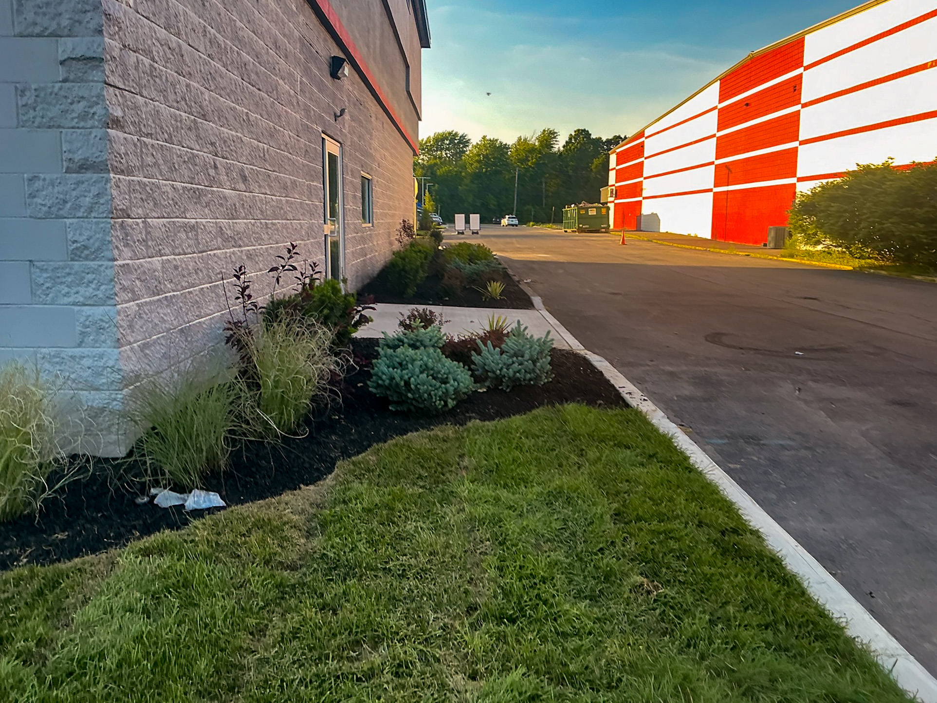 Delta Sonic West Henrietta service building showing Costich's landscape design with ornamental plantings, concrete edging, and integrated grading.
